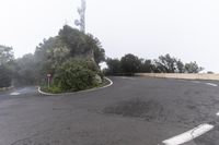 a road with a corner on a foggy day with no cars driving or standing