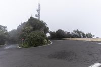 a road with a corner on a foggy day with no cars driving or standing