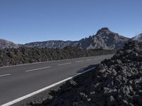 the road that goes into the mountains is surrounded by a pile of rocks and lava