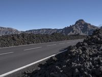 the road that goes into the mountains is surrounded by a pile of rocks and lava