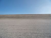 a person on a motorcycle standing on top of a road in the middle of nowhere