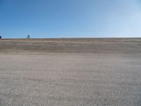 a person on a motorcycle standing on top of a road in the middle of nowhere