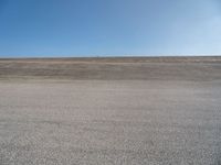 a person on a motorcycle standing on top of a road in the middle of nowhere