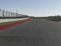 an empty track at a motorsports club with some red and white stripeing on it