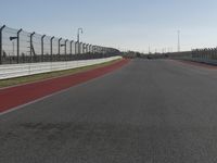 an empty track at a motorsports club with some red and white stripeing on it