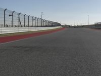 an empty track at a motorsports club with some red and white stripeing on it