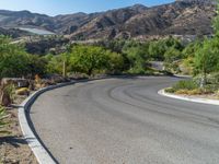 a street view with the mountains in the distance and a road in front of it