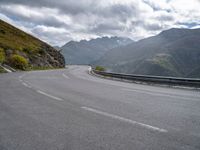 a car is parked on the road in the mountains area of europe with mountains in the background