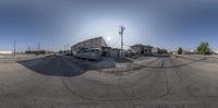 a van sits outside of a vacant lot on the side of a road near two buildings