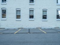 a street with a building near the building in the middle and on the left of which is a parking lot, as shown in this photo