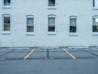 a street with a building near the building in the middle and on the left of which is a parking lot, as shown in this photo