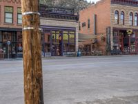 a red fire hydrant sitting in front of an old store window and building next to an open air field