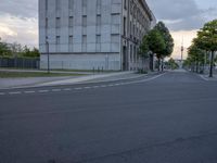 a road with stoplights in front of a building under construction at dusk in europe