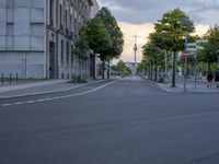 a road with stoplights in front of a building under construction at dusk in europe
