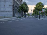 a road with stoplights in front of a building under construction at dusk in europe