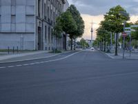 a road with stoplights in front of a building under construction at dusk in europe