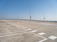 an empty parking lot is shown with some street lights in the foreground and signs to indicate where to go