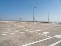 an empty parking lot is shown with some street lights in the foreground and signs to indicate where to go