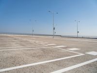 an empty parking lot is shown with some street lights in the foreground and signs to indicate where to go