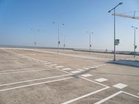 an empty parking lot is shown with some street lights in the foreground and signs to indicate where to go