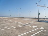 an empty parking lot is shown with some street lights in the foreground and signs to indicate where to go