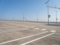 an empty parking lot is shown with some street lights in the foreground and signs to indicate where to go