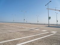 an empty parking lot is shown with some street lights in the foreground and signs to indicate where to go