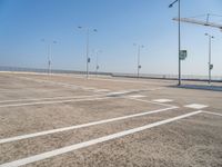 an empty parking lot is shown with some street lights in the foreground and signs to indicate where to go