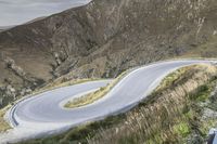 Road Through New Zealand Highland Landscape with Mountains and Grass