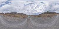 the image is taken from a computer screen of a desert road with mountains in the distance