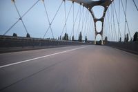 a view from behind of a moving car on the bridge in a city at dusk