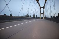 a view from behind of a moving car on the bridge in a city at dusk