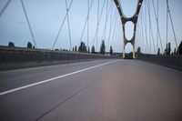 a view from behind of a moving car on the bridge in a city at dusk