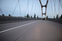 a view from behind of a moving car on the bridge in a city at dusk