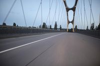 a view from behind of a moving car on the bridge in a city at dusk