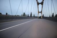 a view from behind of a moving car on the bridge in a city at dusk