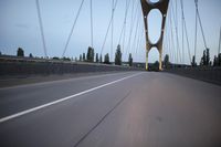 a view from behind of a moving car on the bridge in a city at dusk