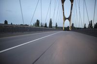 a view from behind of a moving car on the bridge in a city at dusk