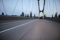 a view from behind of a moving car on the bridge in a city at dusk