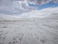 the sky is very cloudy with the clouds in it with dirt all around it and a desert, but only a cloud