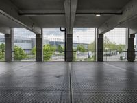 an empty parking garage with open doors on the side and a wire fence in front