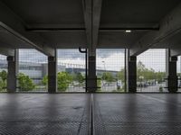 an empty parking garage with open doors on the side and a wire fence in front