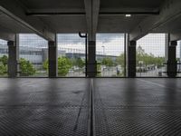 an empty parking garage with open doors on the side and a wire fence in front