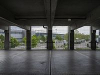 an empty parking garage with open doors on the side and a wire fence in front