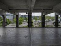 an empty parking garage with open doors on the side and a wire fence in front