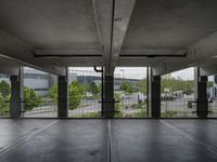 an empty parking garage with open doors on the side and a wire fence in front