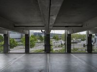 an empty parking garage with open doors on the side and a wire fence in front