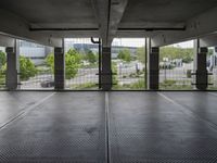 an empty parking garage with open doors on the side and a wire fence in front