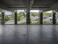 an empty parking garage with open doors on the side and a wire fence in front