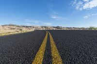 the long road is lined with black pebbles and yellow stripes the middle has white clouds